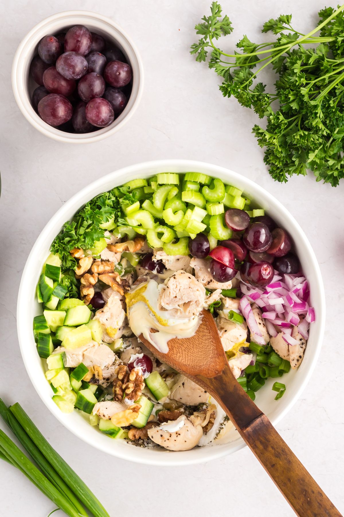 Ingredients being mixed in a bowl with a wooden spoon. 