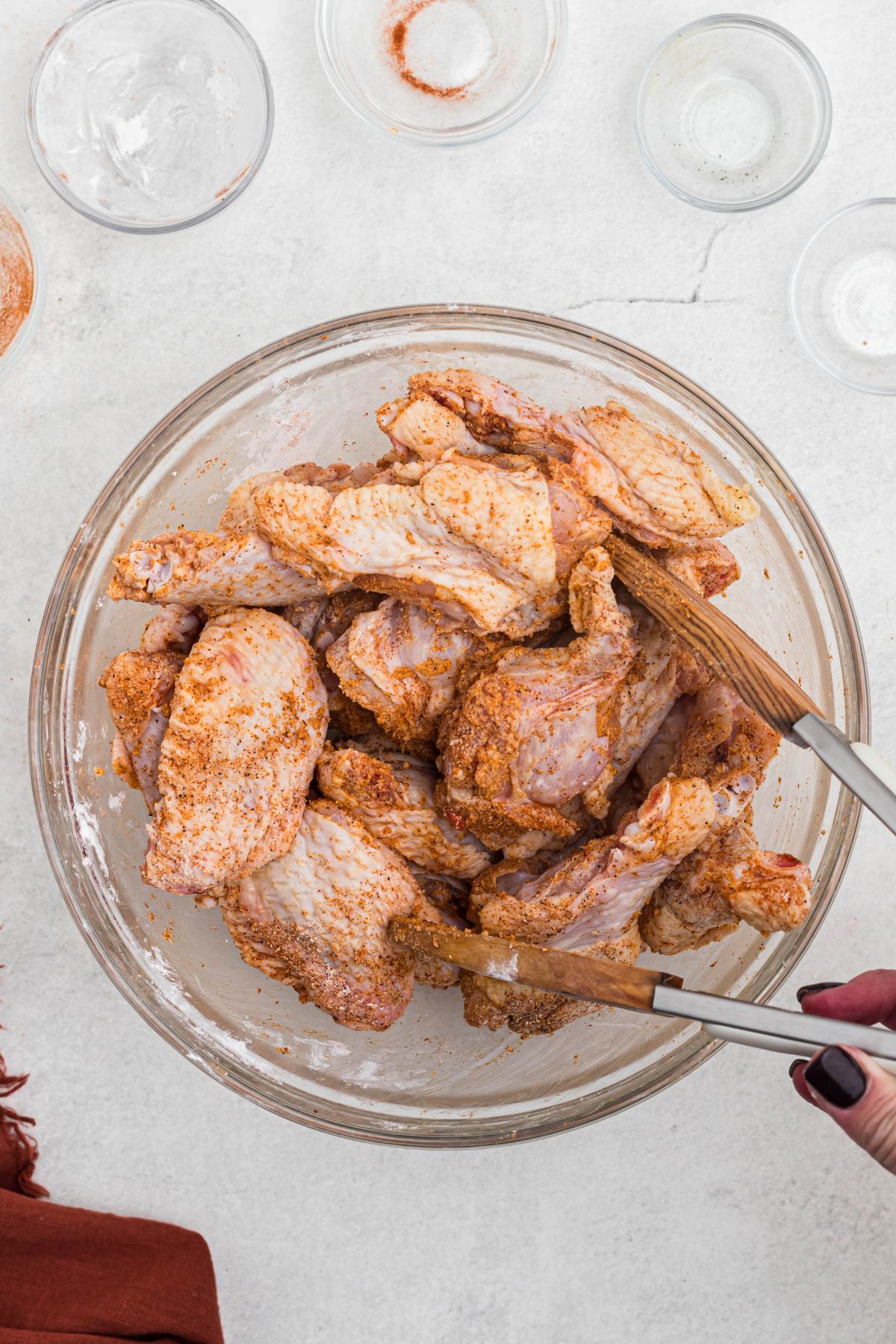 Uncooked chicken wings, tossed in seasonings and placed on a rack over a baking sheet. 