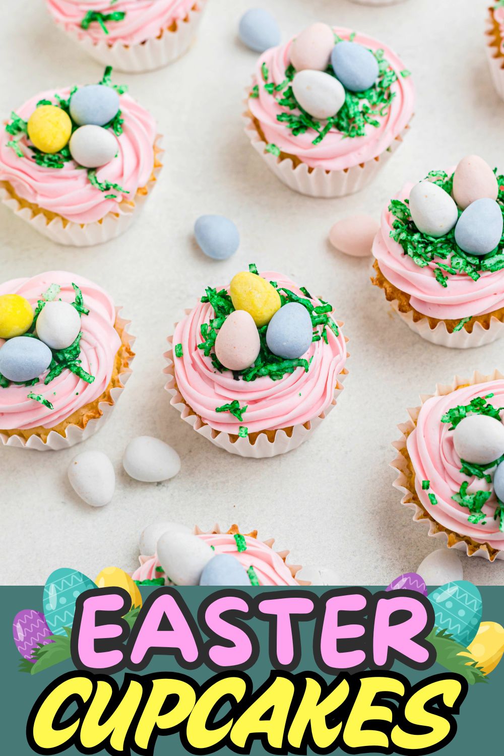 Vanilla cupcakes topped with pink frosting, green coconut, and egg shaped chocolates.