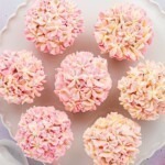 Pink and white pretty hydrangea cupcakes on a white baking dish.