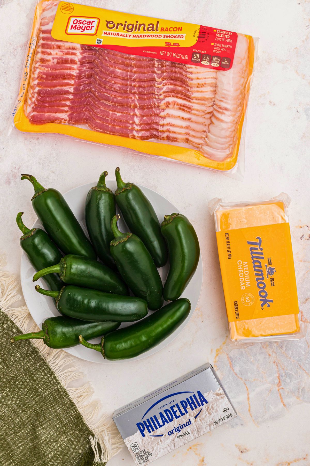 Jalapenos, bacon, cheese, and cream cheese on a marble table. 