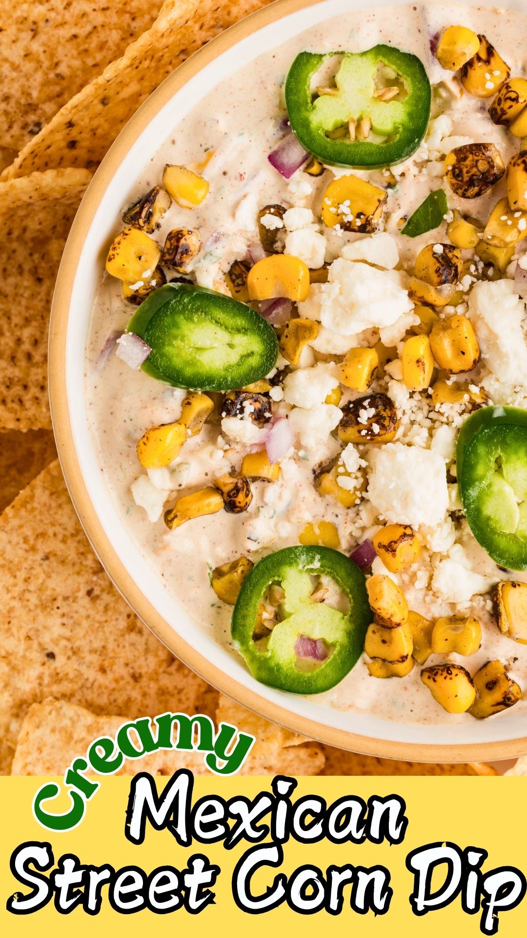 Creamy Mexican corn dip in a white bowl, surrounded by tortilla chips for dipping.