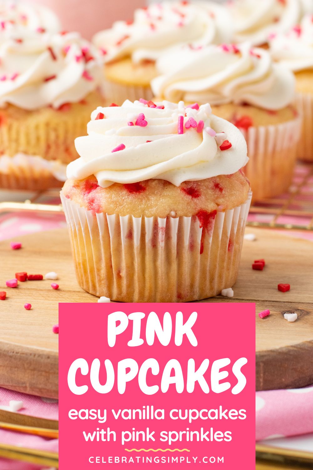 Vanilla cupcake filled with pink sprinkles and topped with white frosting and pink sprinkles.