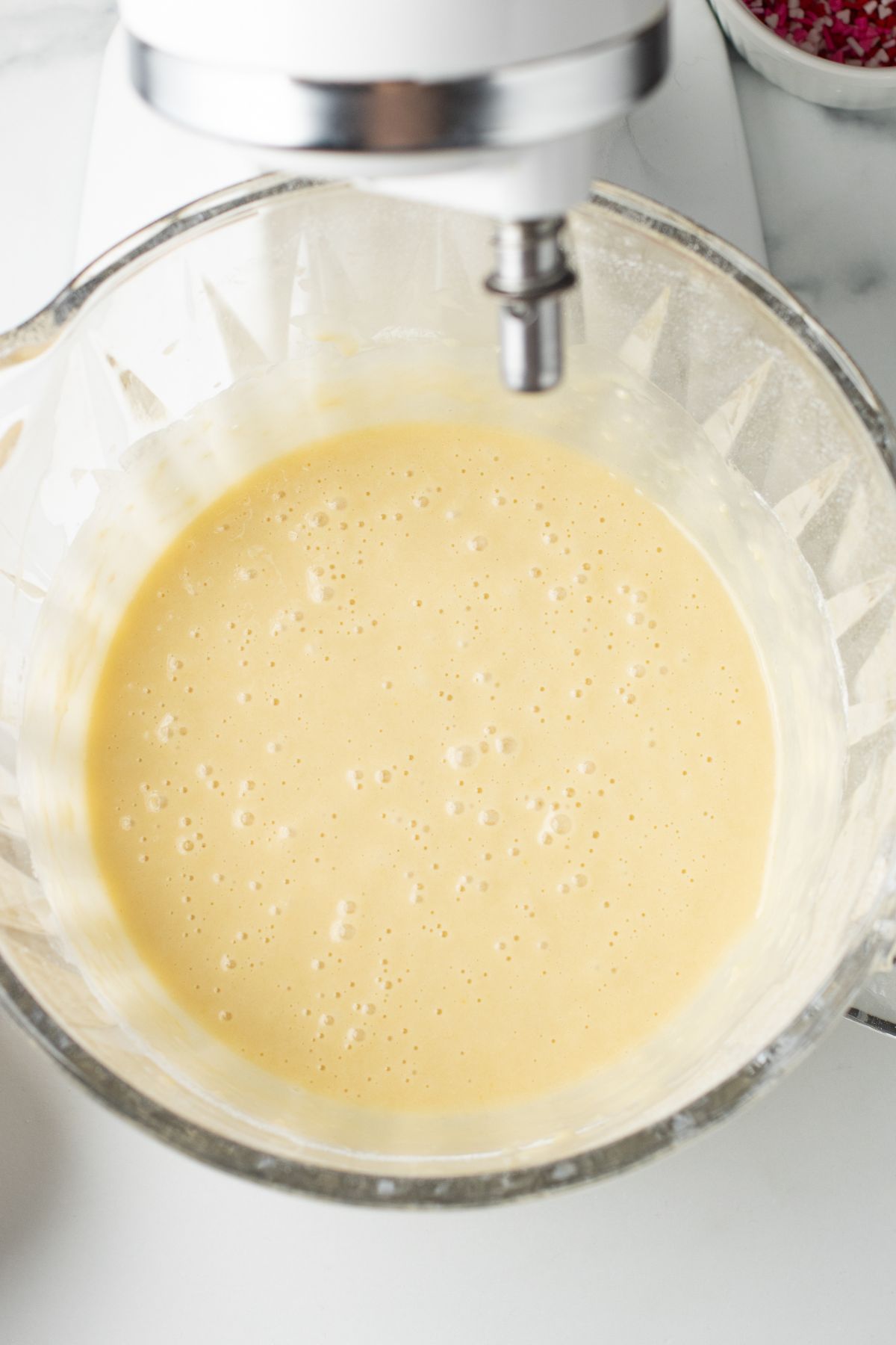 Cupcake batter in a glass mixing bowl. 