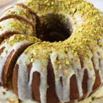 Bundt cake on a platter with a few slices made into the left side of the cake.