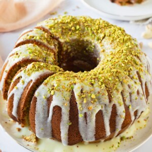 Bundt cake on a platter with a few slices made into the left side of the cake.