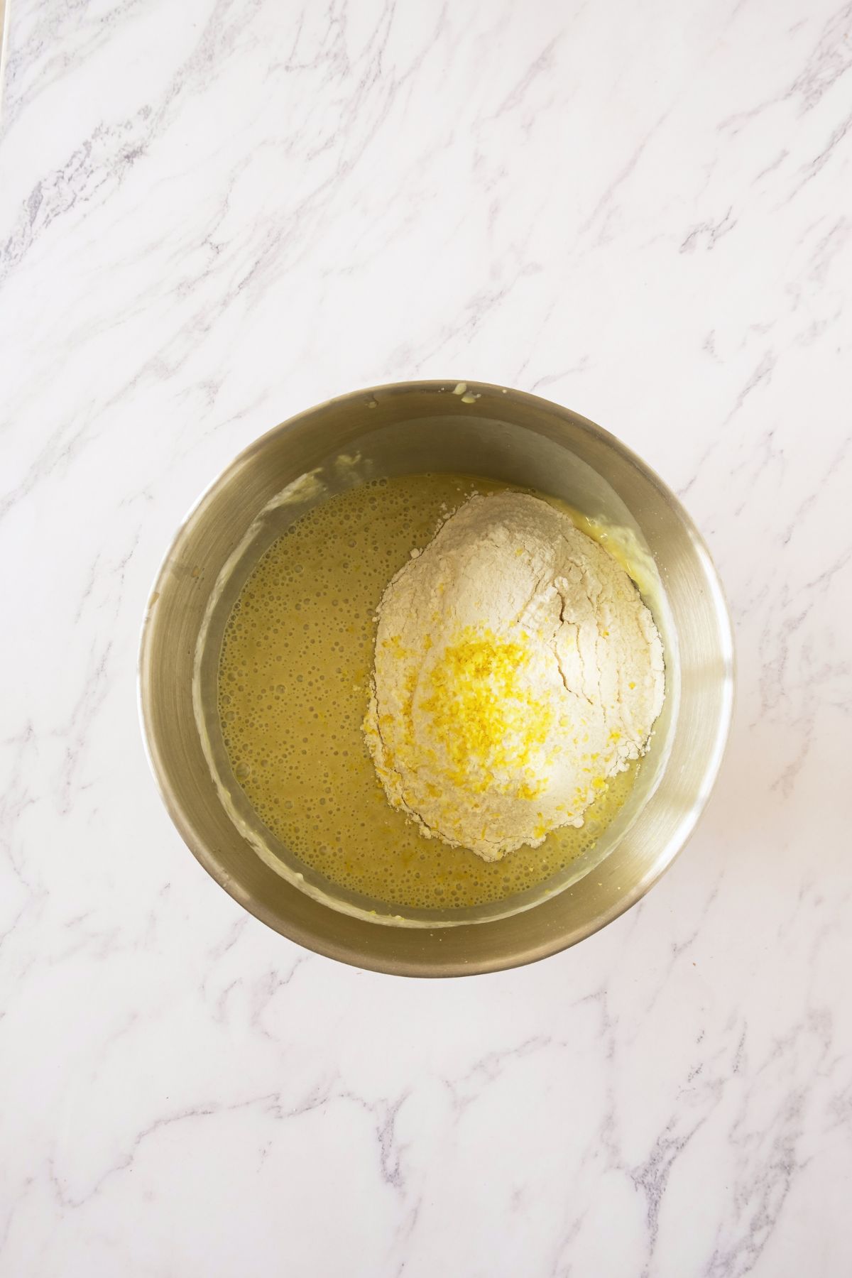 Ingredients mixed together in a large silver bowl.