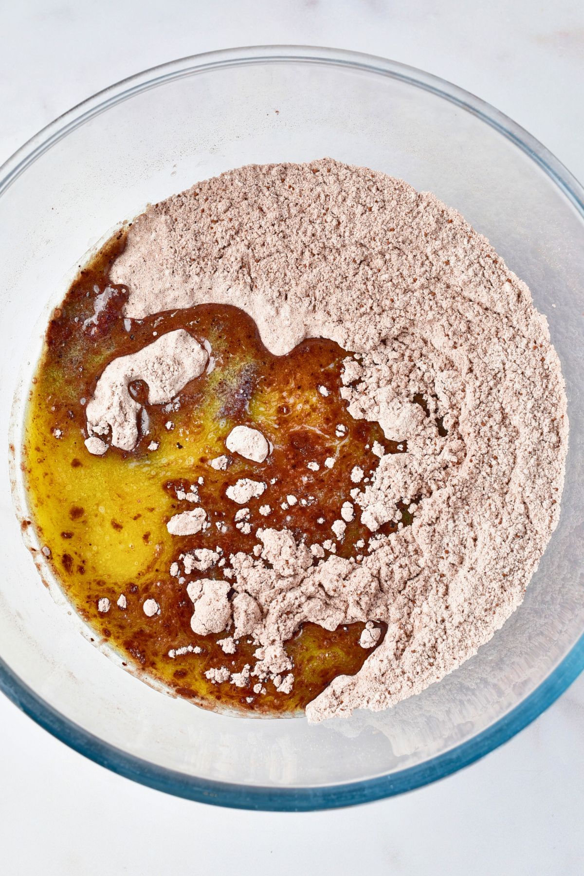 Ingredients being mixed in a large glass bowl. 