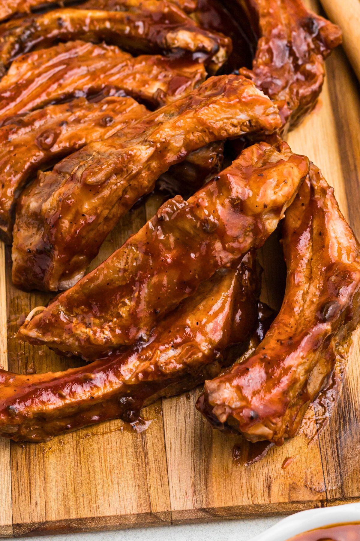 Juicy baby back BBQ ribs on a wooden cutting board. 