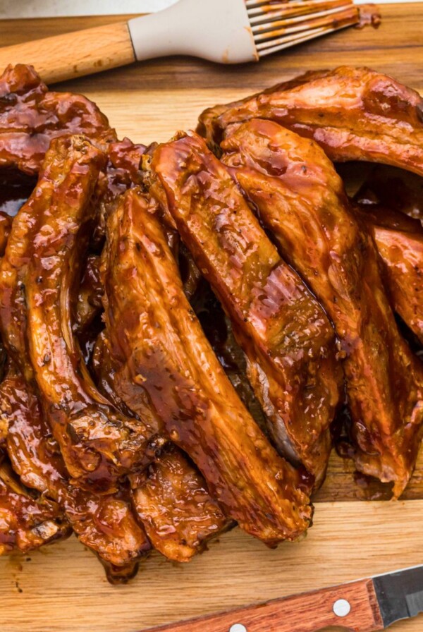 Juicy baby back BBQ ribs on a wooden cutting board.