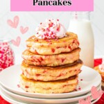 Golden fluffy stacked pancakes on a white plate, filled with Valentine's sprinkles.