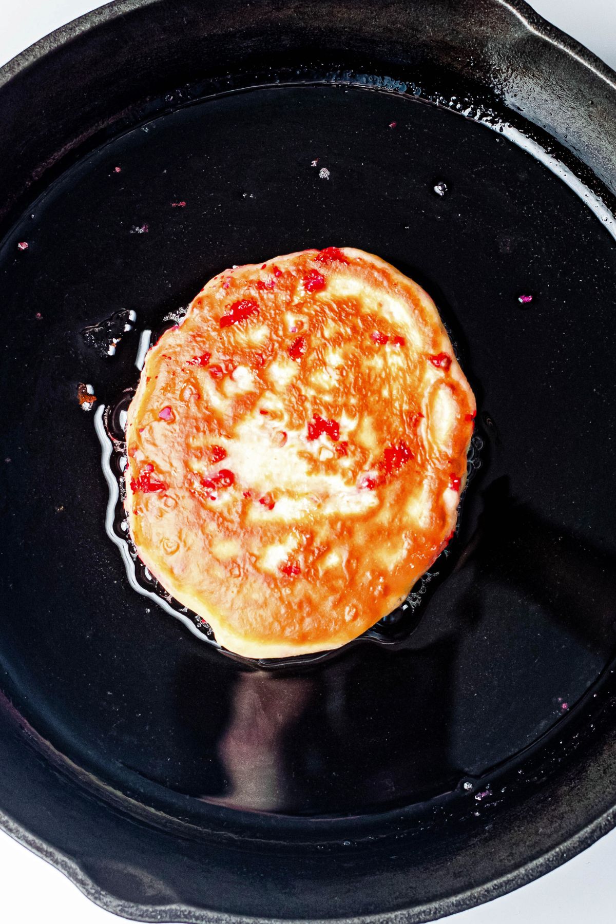 Golden pancake in a black skillet.