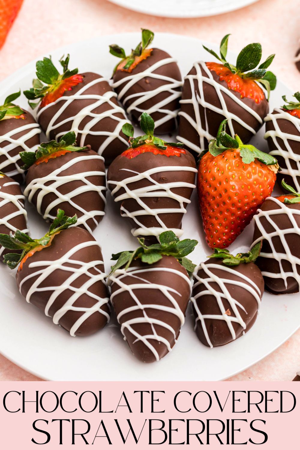 Chocolate covered strawberries on a white plate sitting on a pink table.