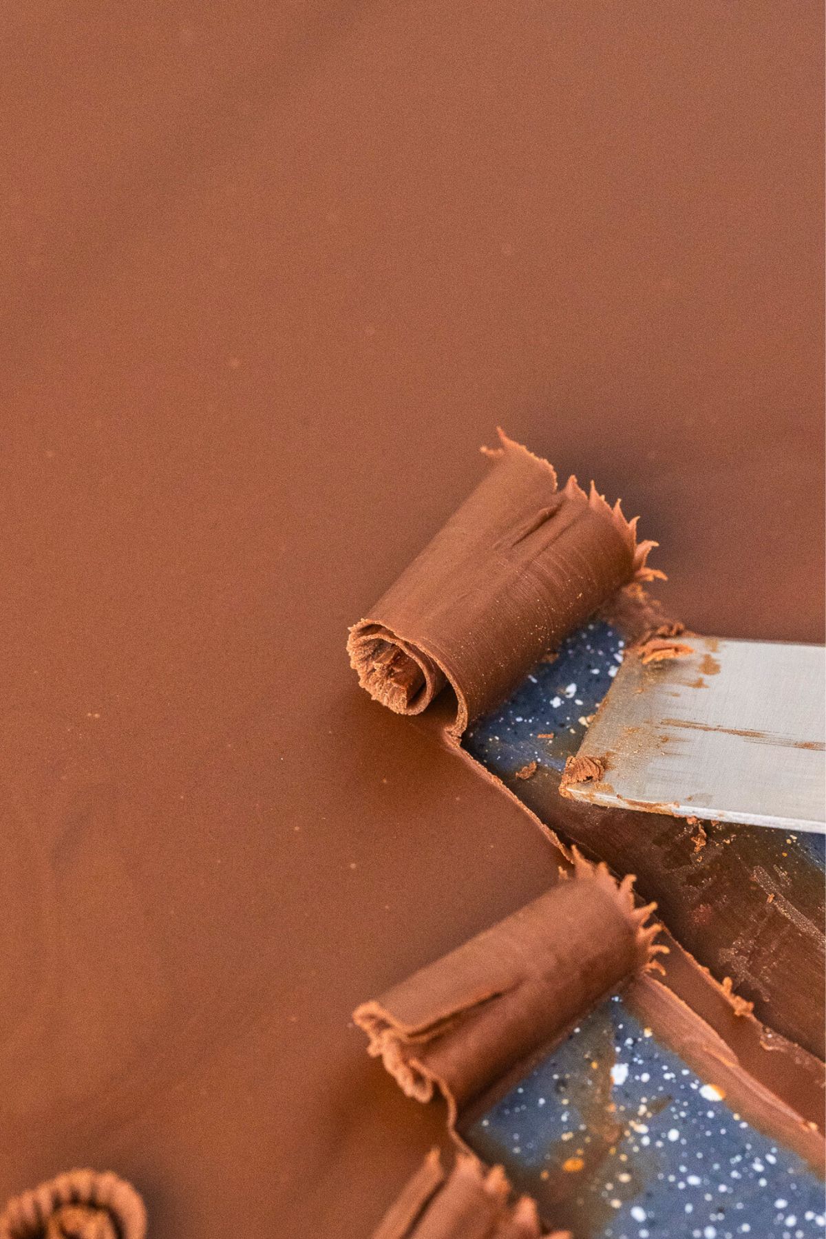 Large curls being made with an offset spatula. 