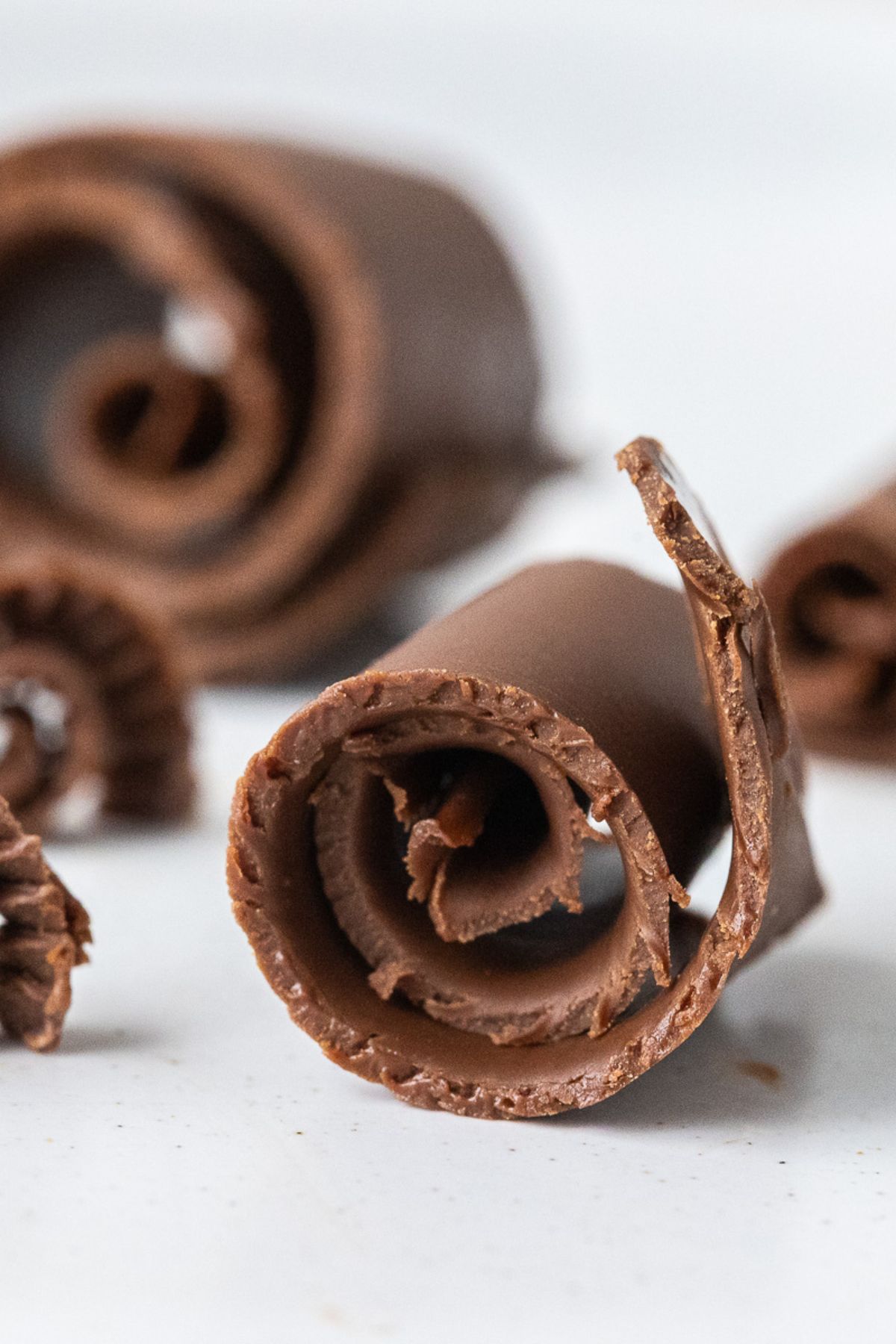 Chocolate curls on a white plate. 