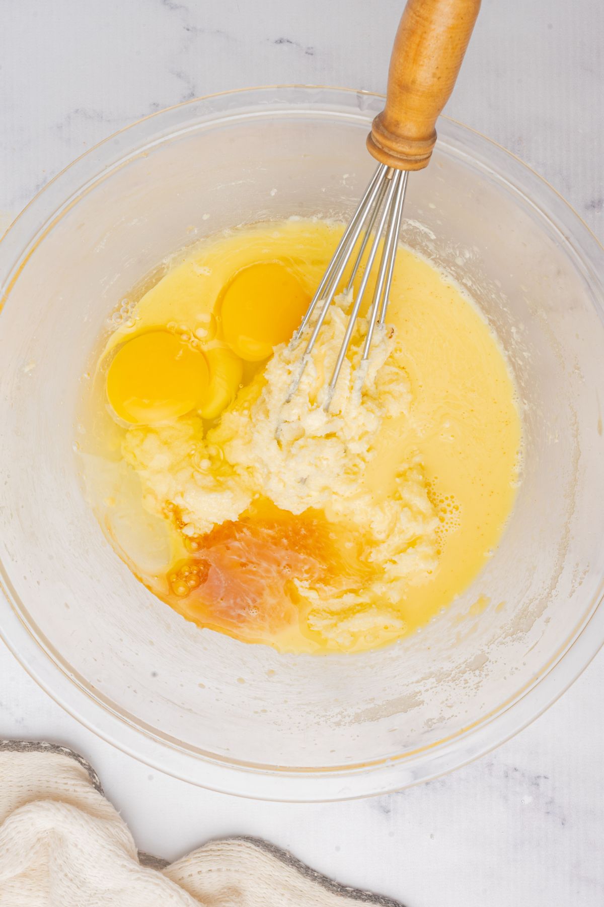 Cupcakes ingredients being mixed in a large clear glass bowl. 