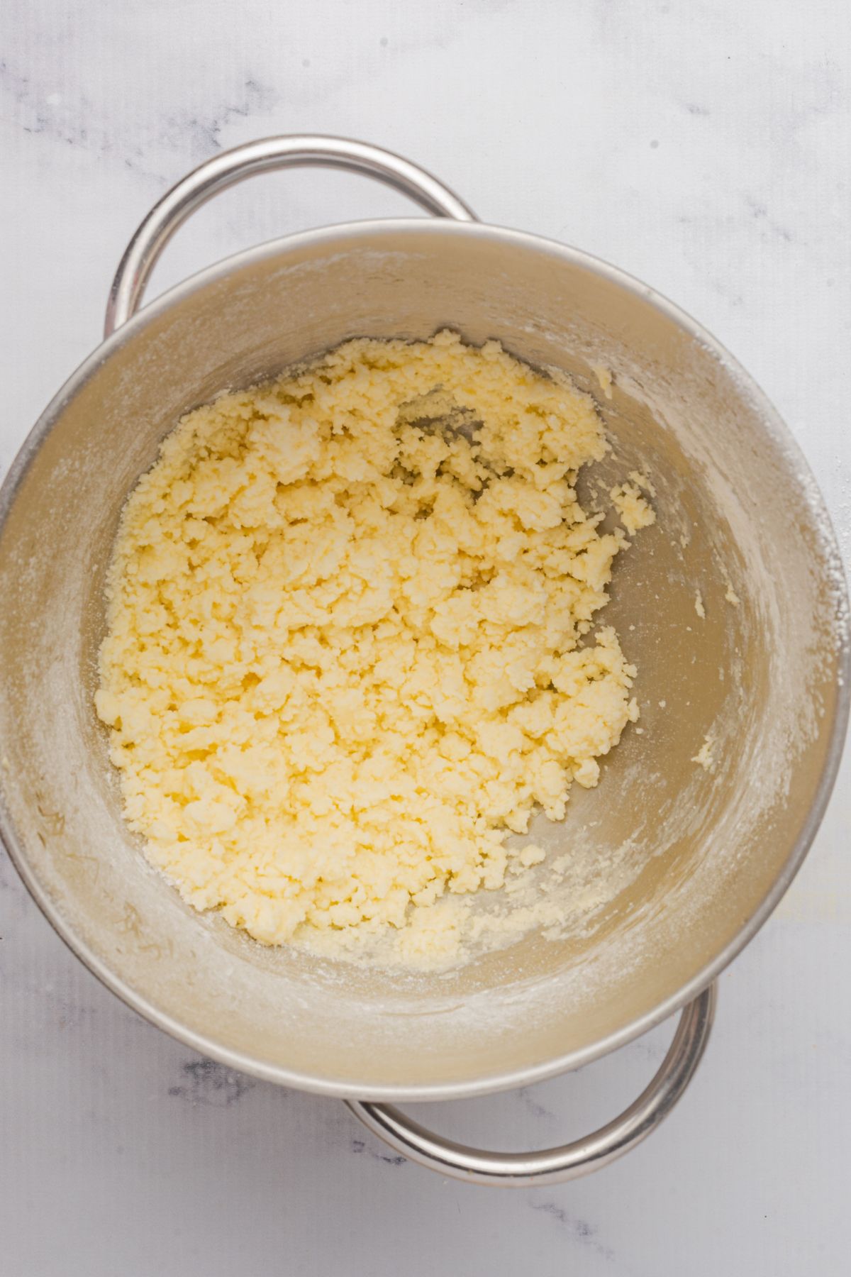 Creamy buttercream frosting in a large metal bowl. 