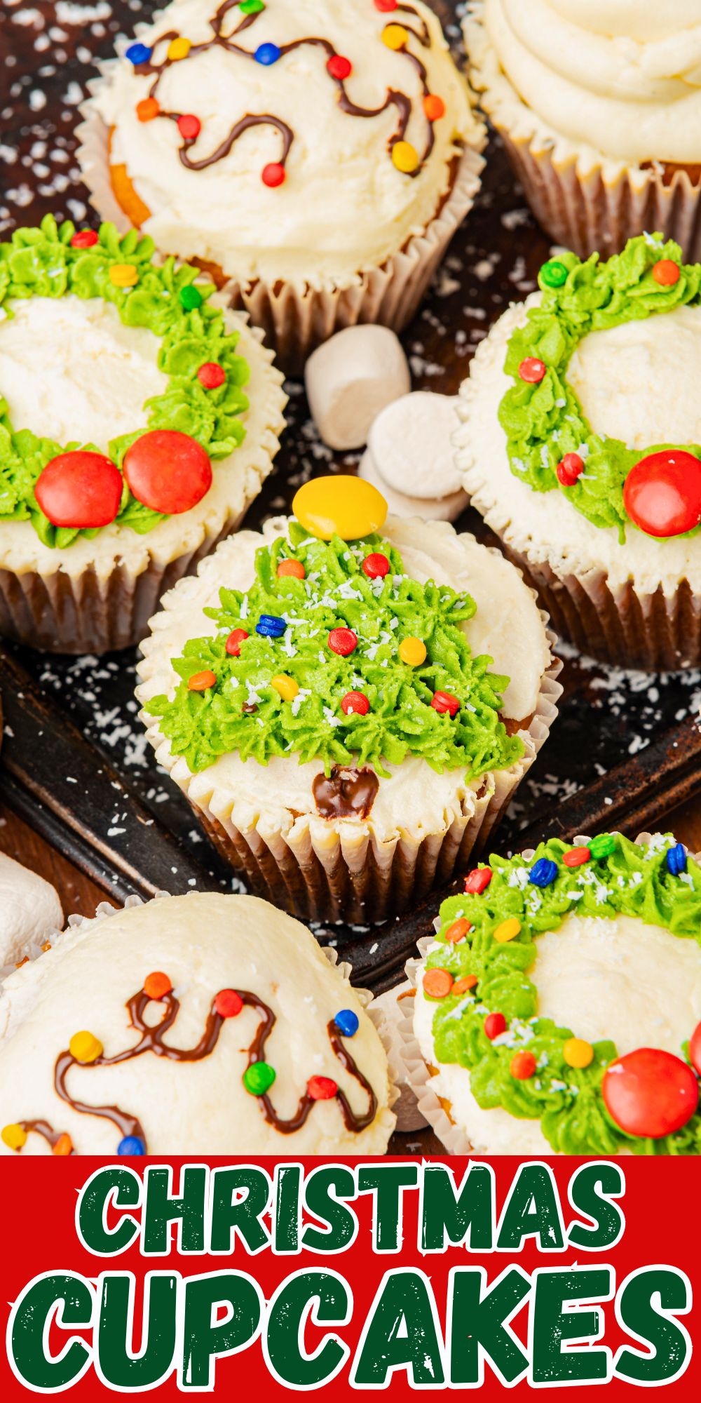 Christmas cupcakes with trees, wreaths, and lights decorations, on a table.