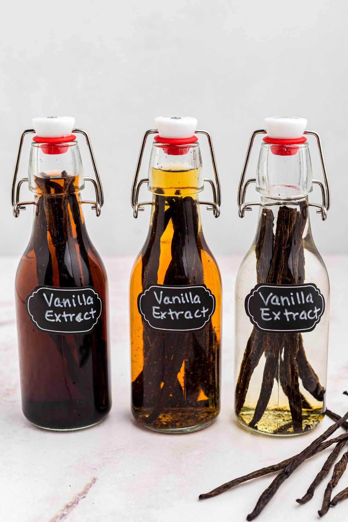 Three bottles of vanilla in different stages of sitting with pods. 