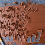 Chocolate spread onto a baking sheet, making chocolate curls.