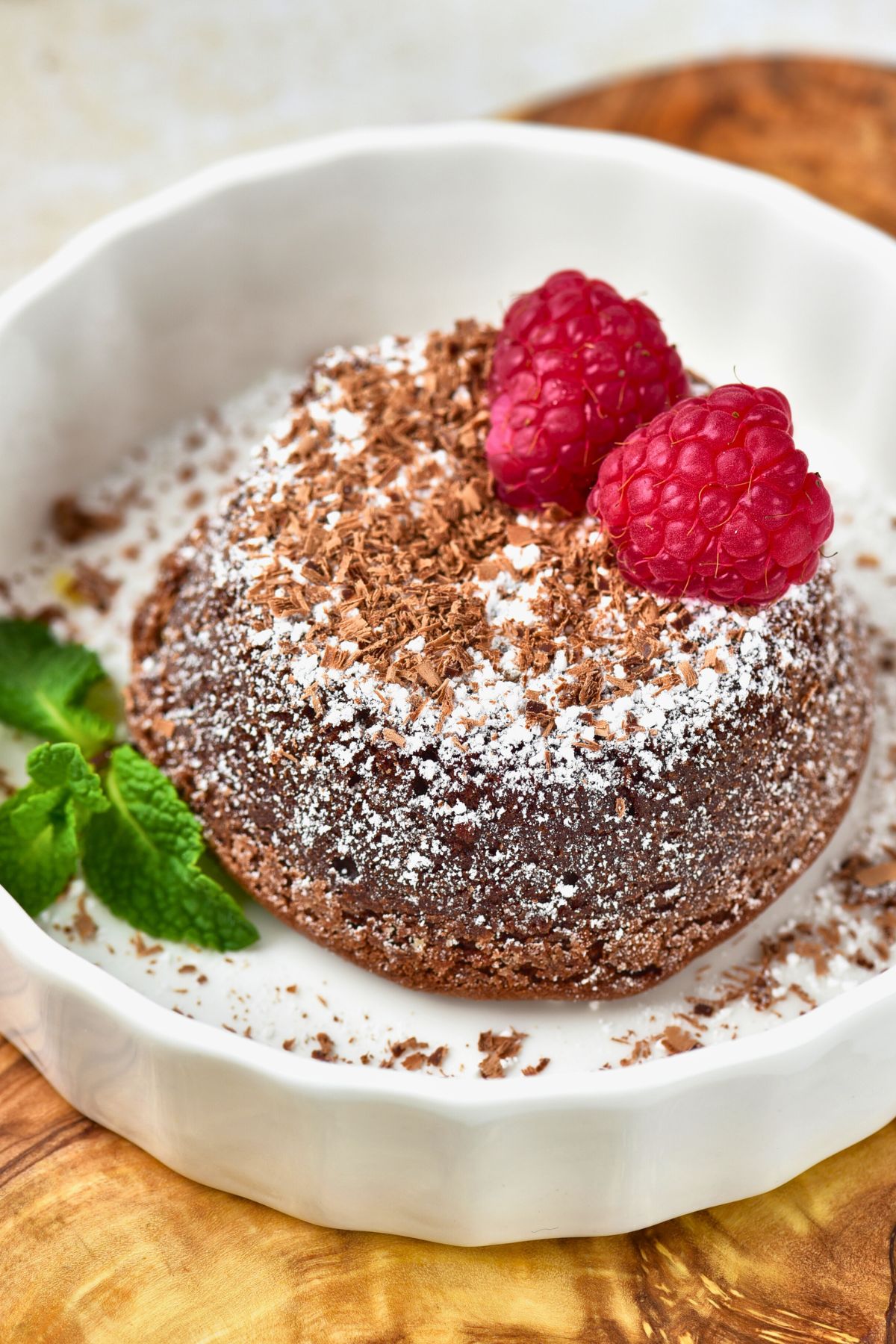 Chocolate lava cake on a white plate before being cut into. 