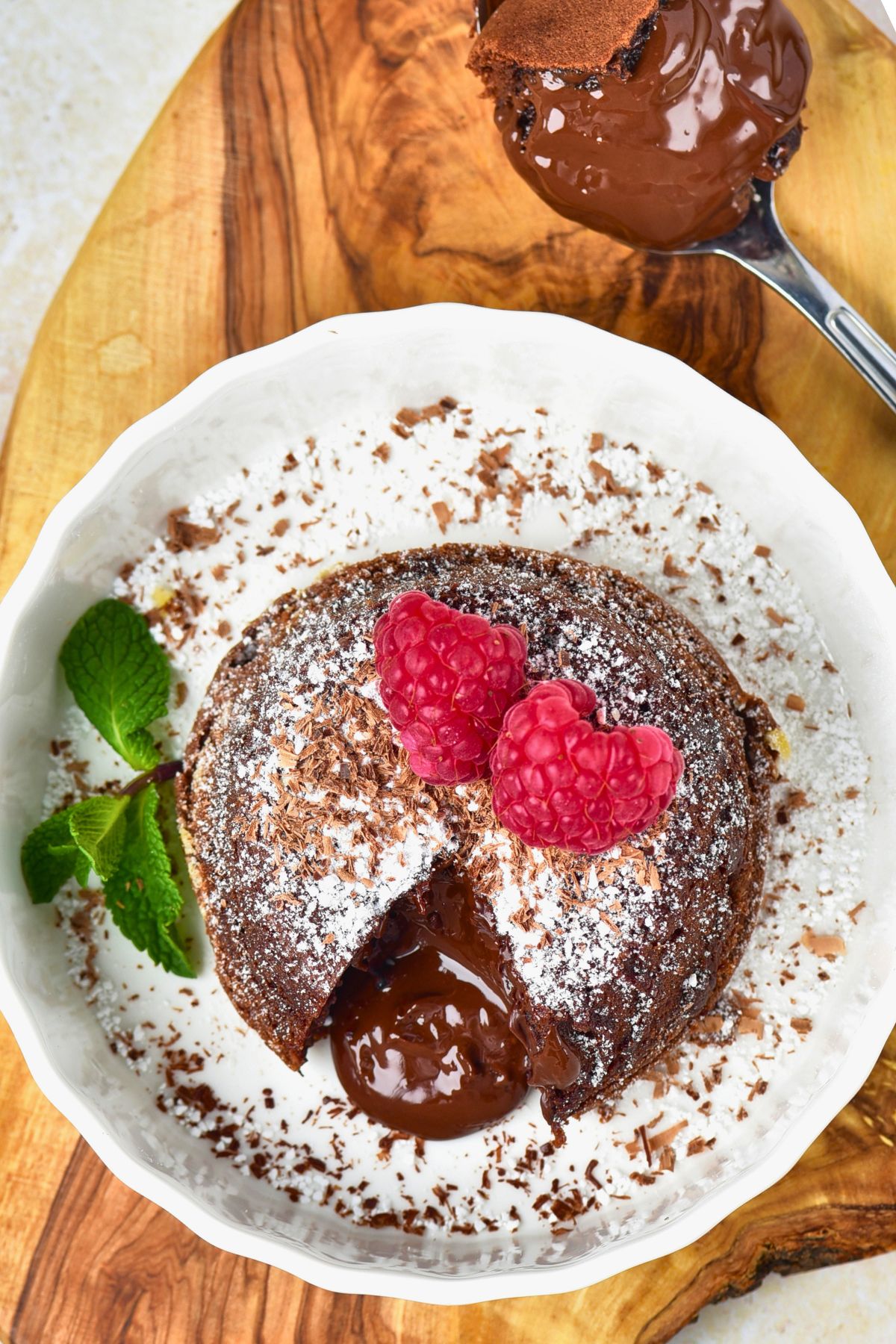 Chocolate mini cake with gooey center coming out onto a white plate.