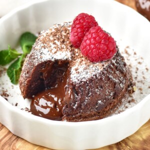 Chocolate mini cake with gooey center coming out onto a white plate.