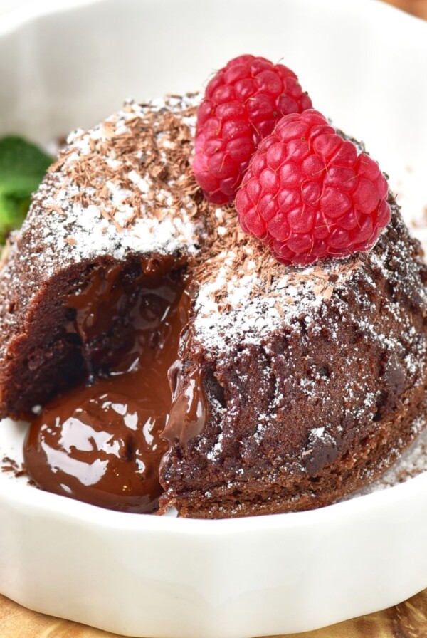 Chocolate mini cake with gooey center coming out onto a white plate.