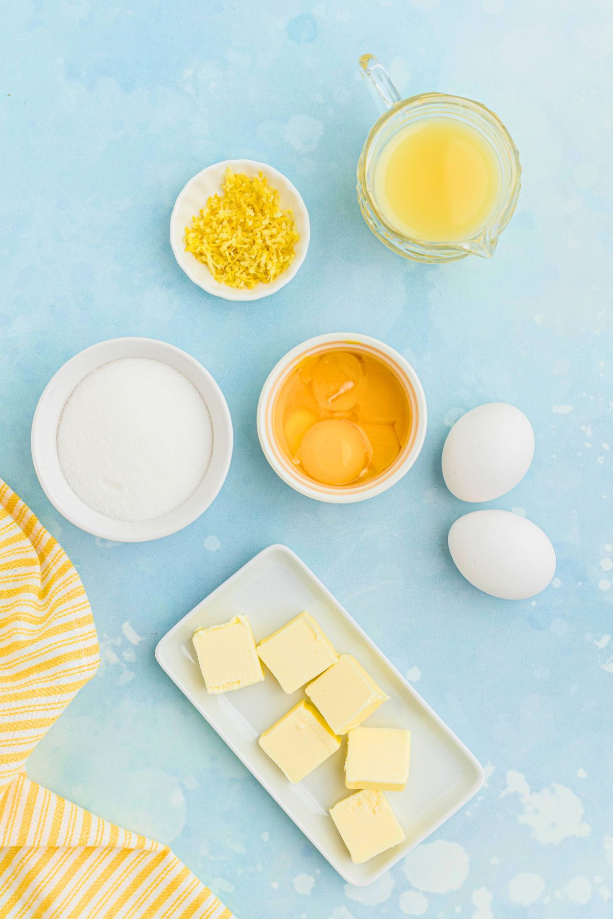 Ingredients measured into small bowls on a light blue table. 