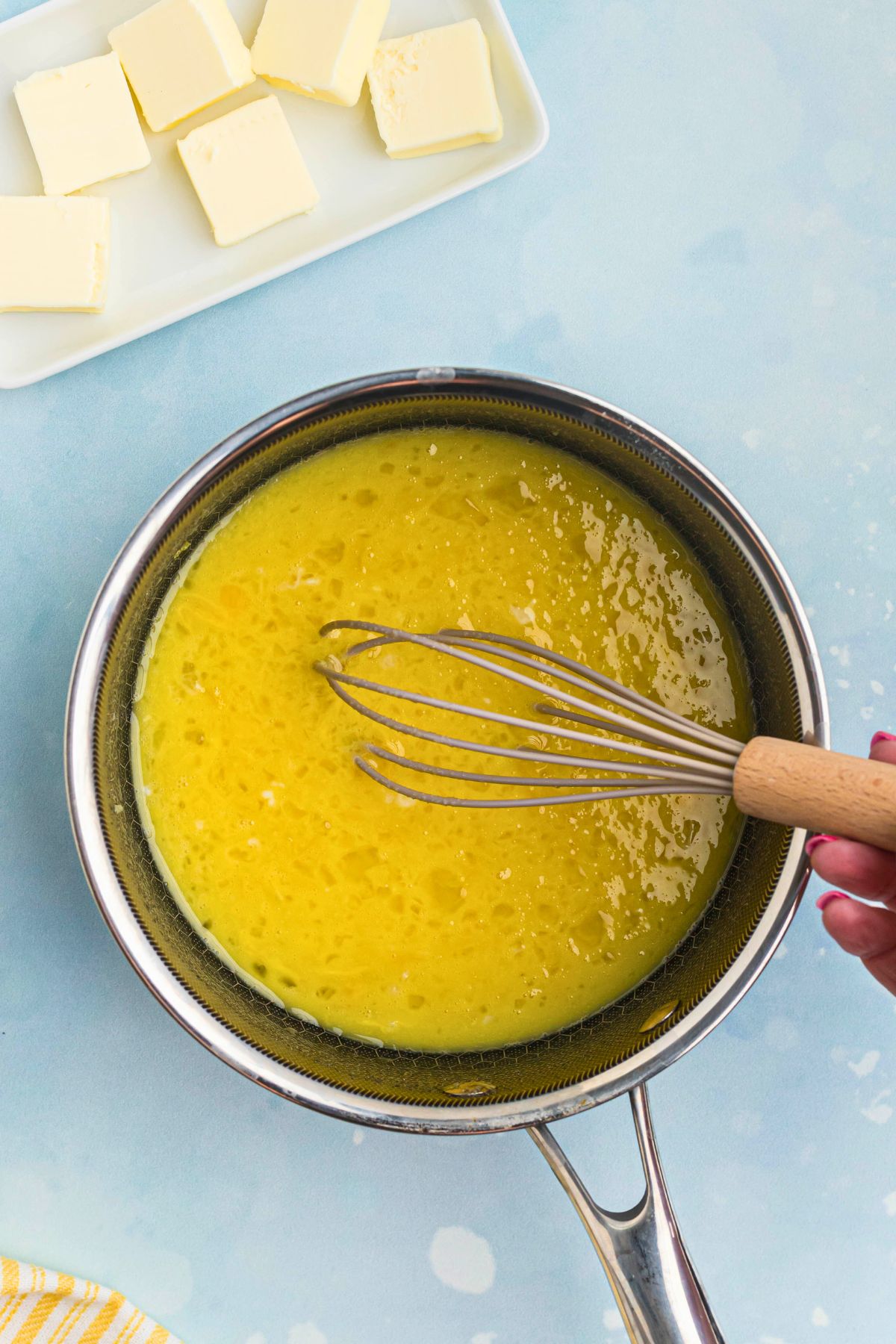 Eggs being whisked in a saucepan with other ingredients. 