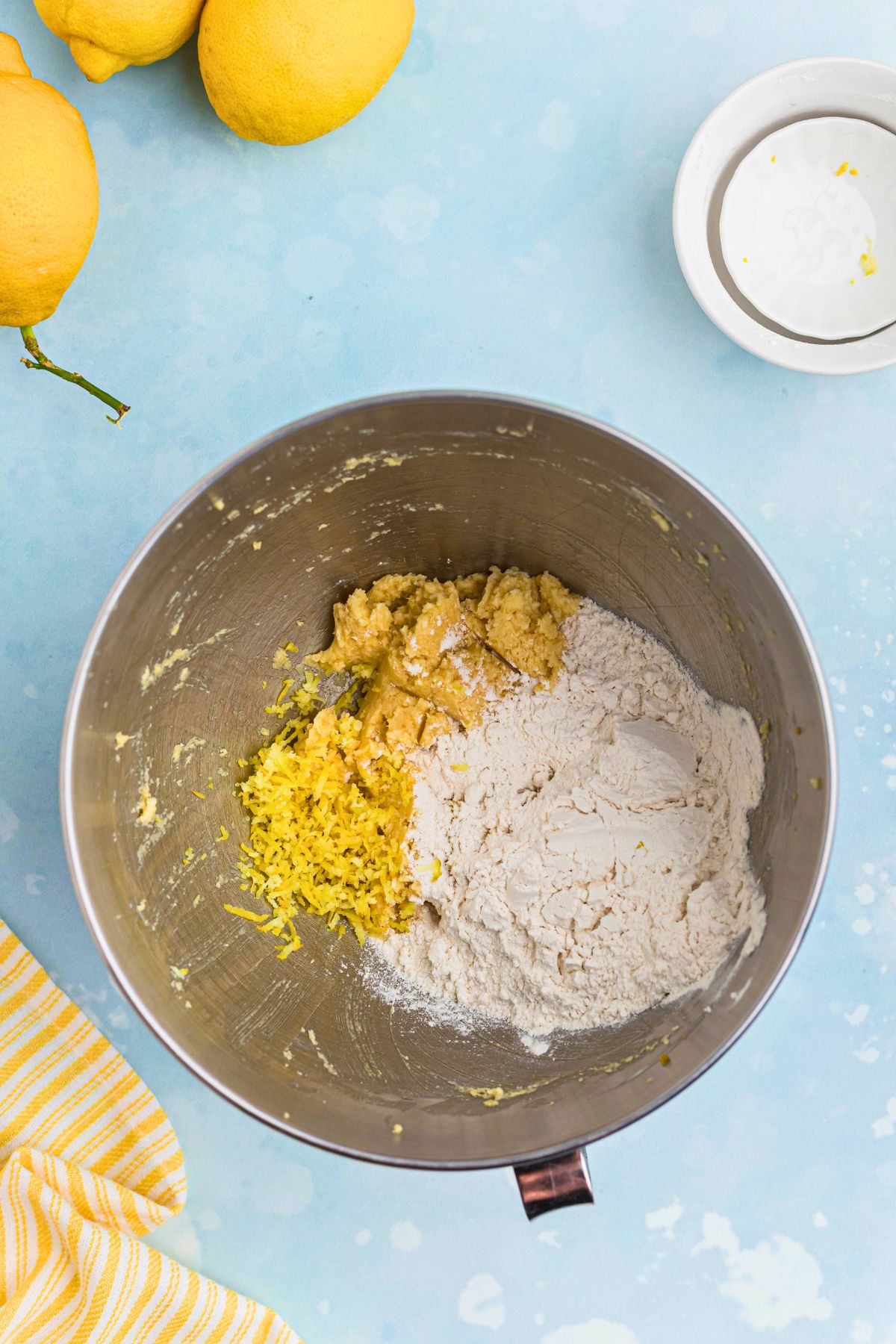 Cookie dough ingredients being mixed together in a silver mixing bowl. 