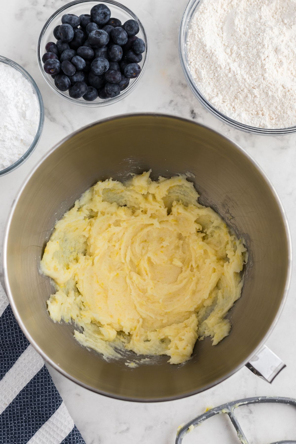 Butter and sugars with other ingredients, mixed together in mixing bowl. 