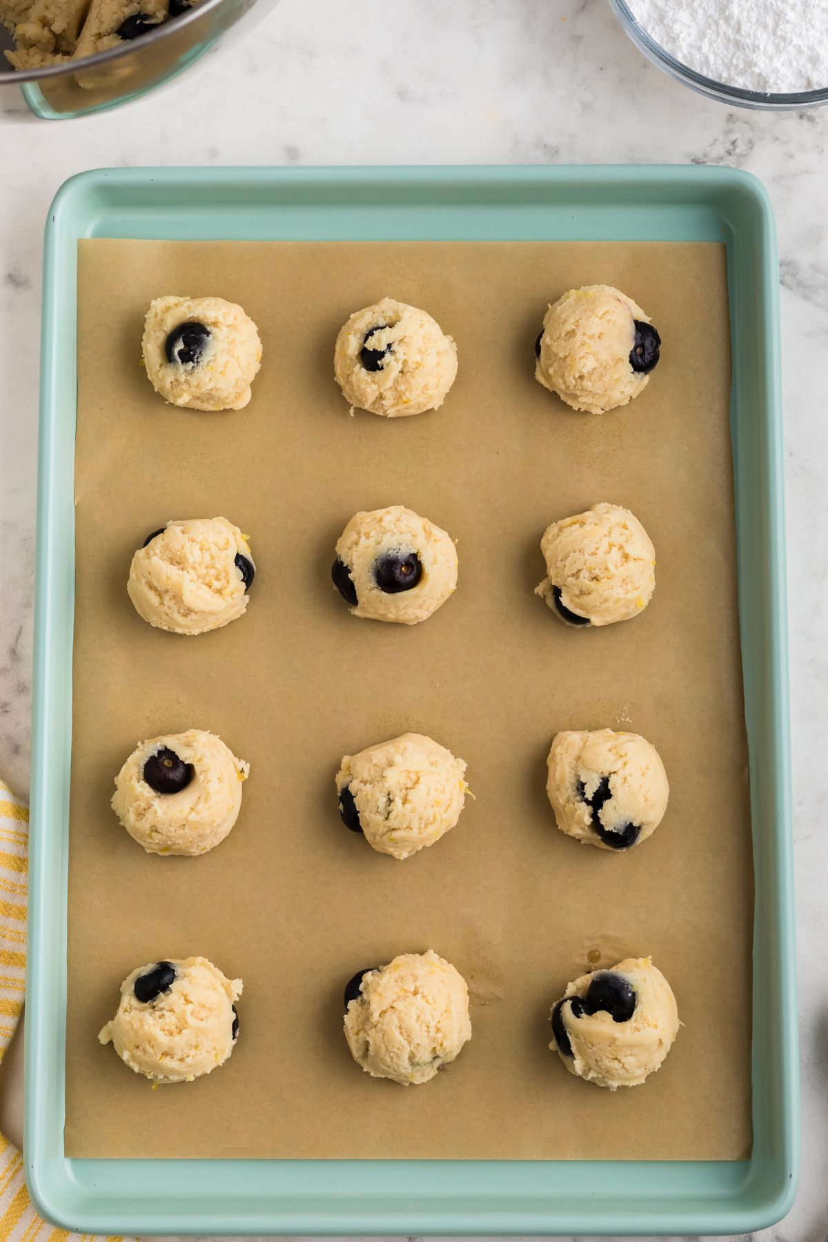 Cookie dough measured with portion scoop onto baking sheet lined with parchment paper. 