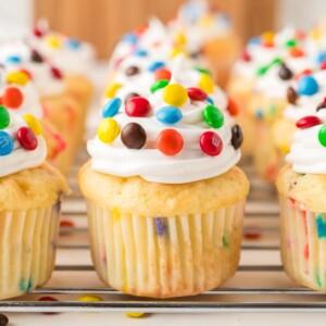 Funfetti cupcakes filled with m and m's, then topped with vanilla frosting and more candies.