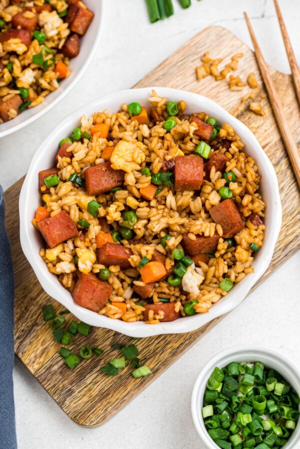 Spam, rice, and veggies, cooked and mixed together in a white bowl.