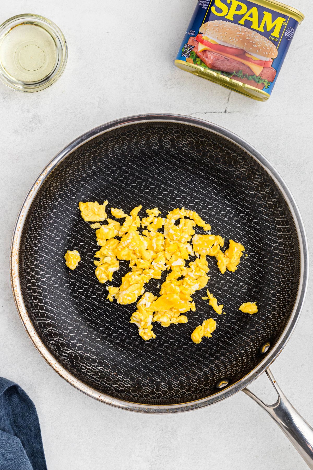 Scrambled eggs in a skillet on a marble table. 