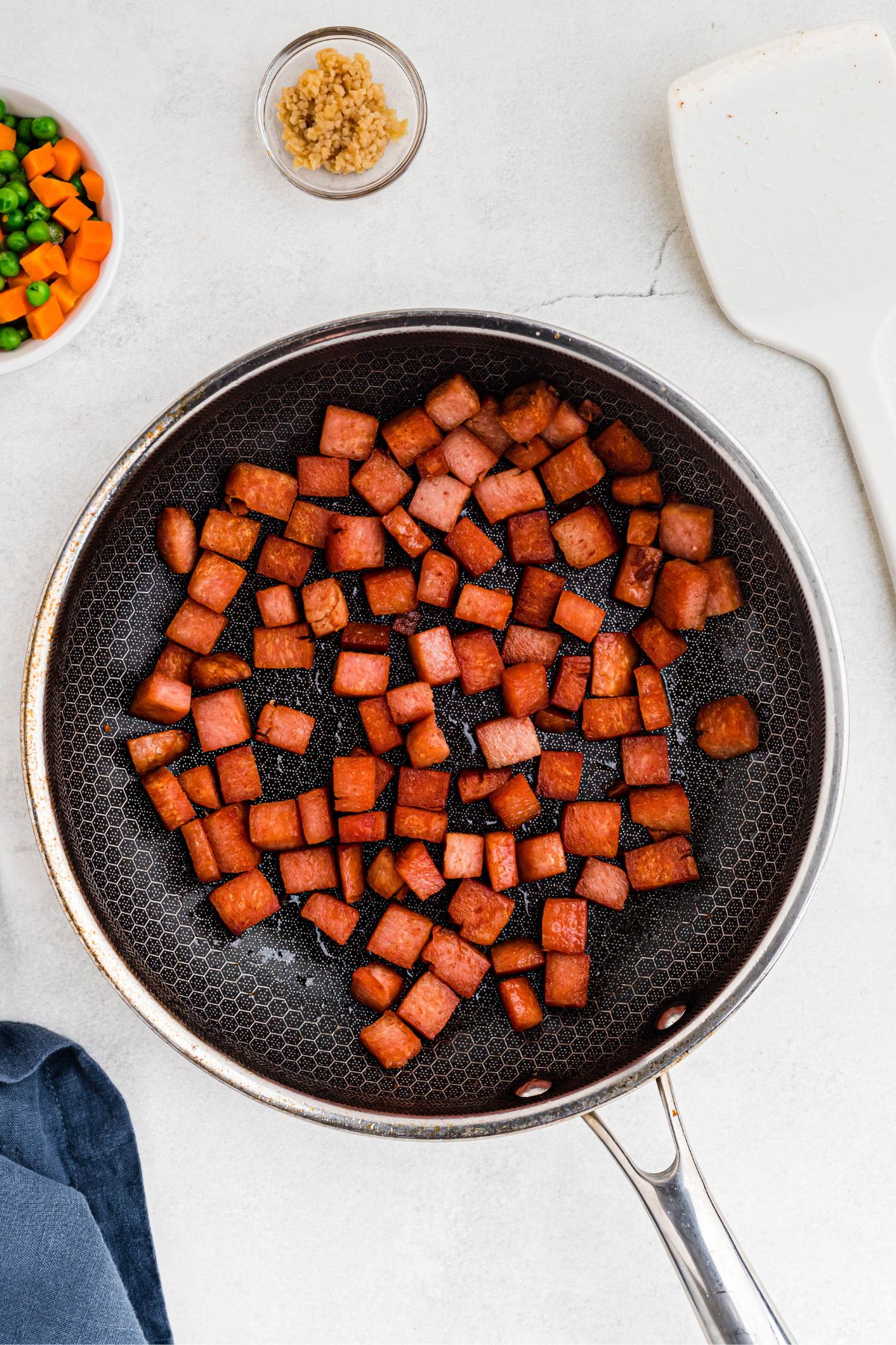 Pieces of Spam, cooked in a skillet until golden brown and crispy. 