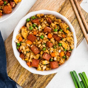 Spam, rice, and veggies, cooked and mixed together in a white bowl.