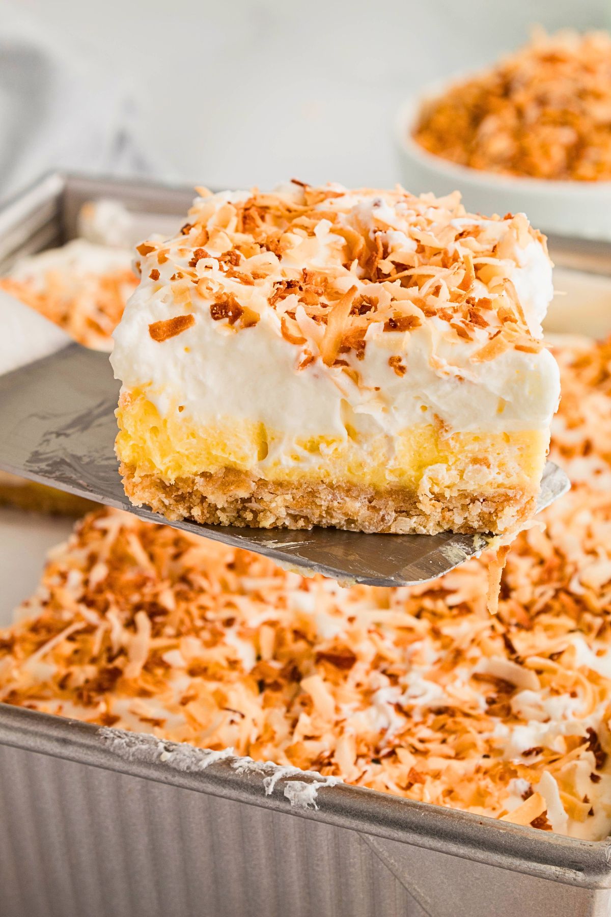 Slice of creamy pie being lifted out of a pan with a spatula. 