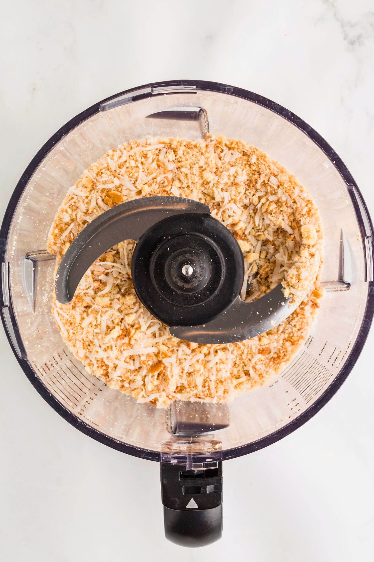 cookies and coconut being pulsed together in a food processor. 