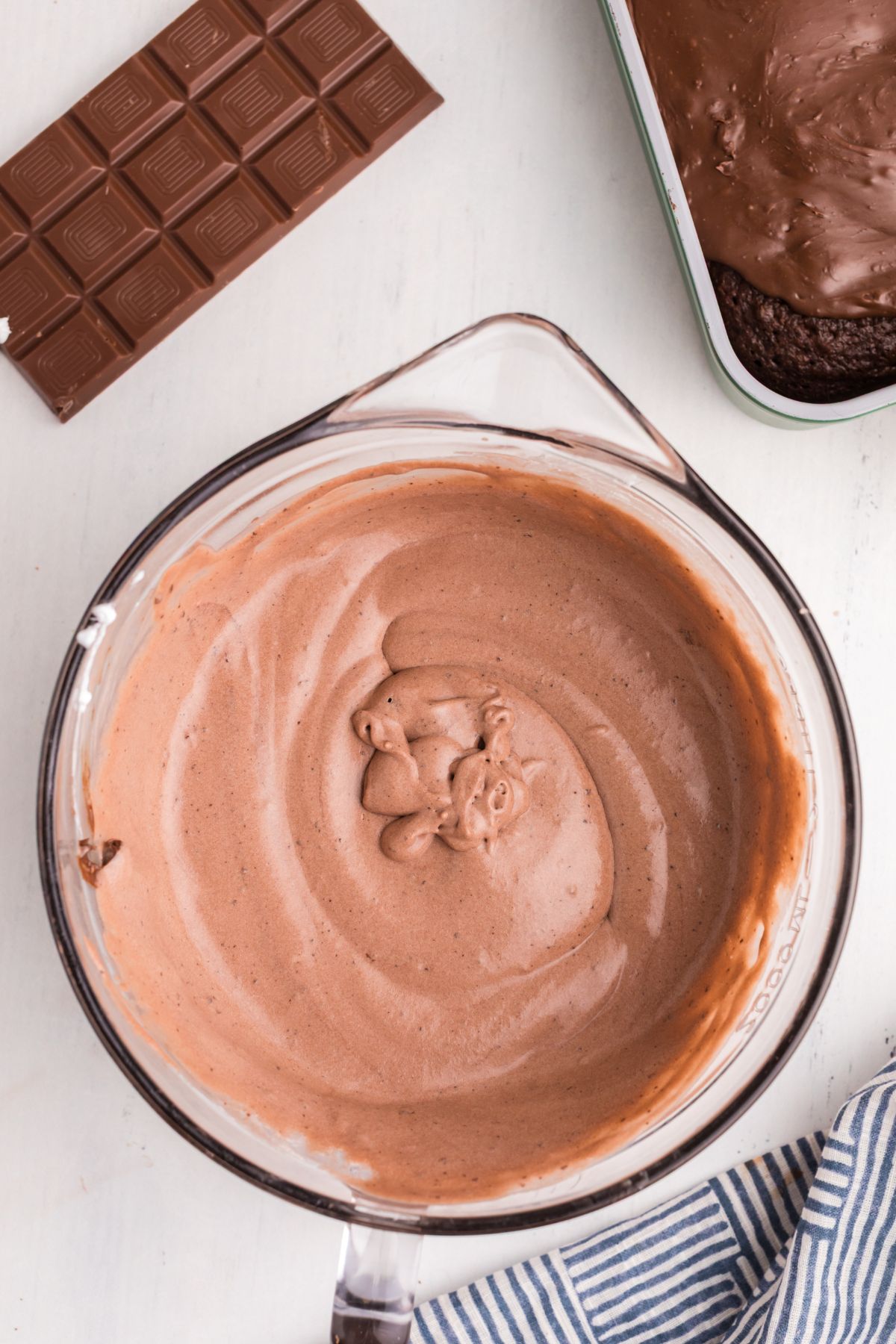 Whipped cream mixed with chocolate pudding mix in a clear glass bowl.