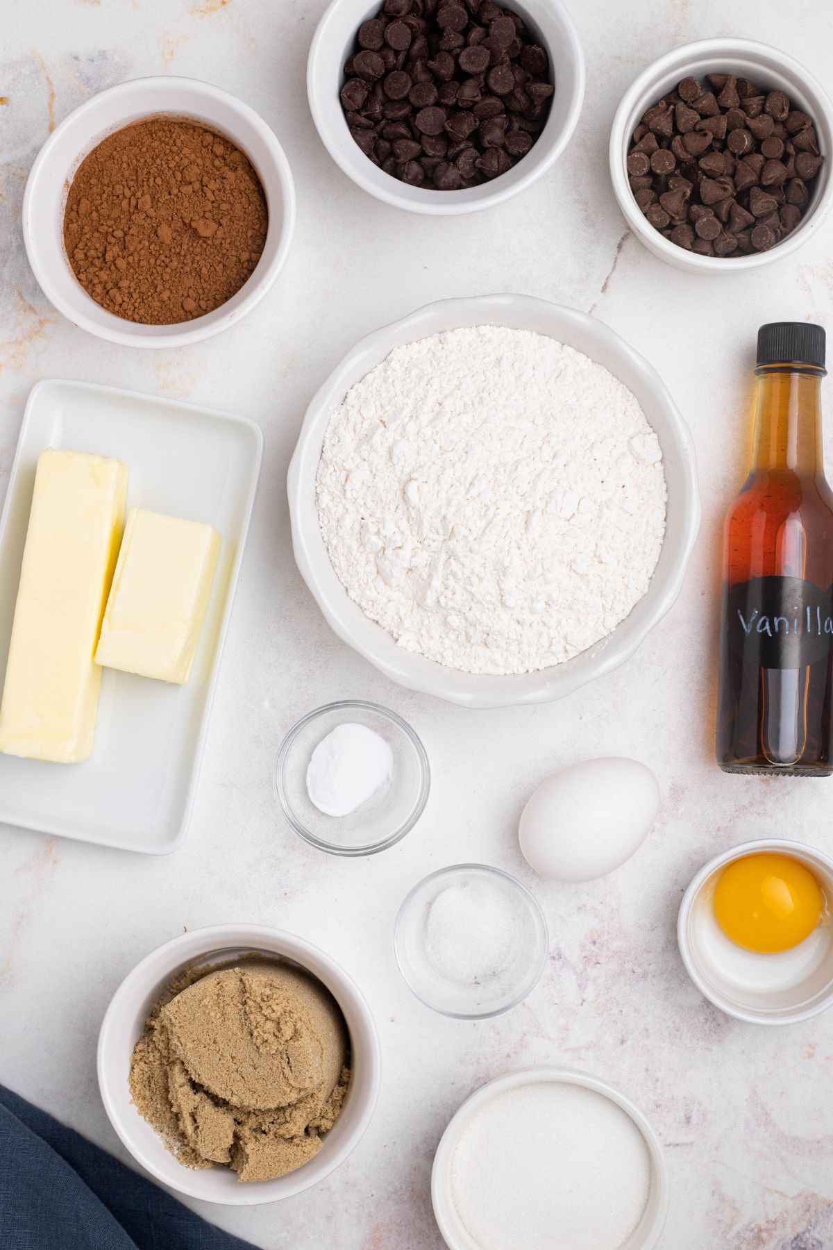 Ingredients measured out in small bowls on a marble table. 