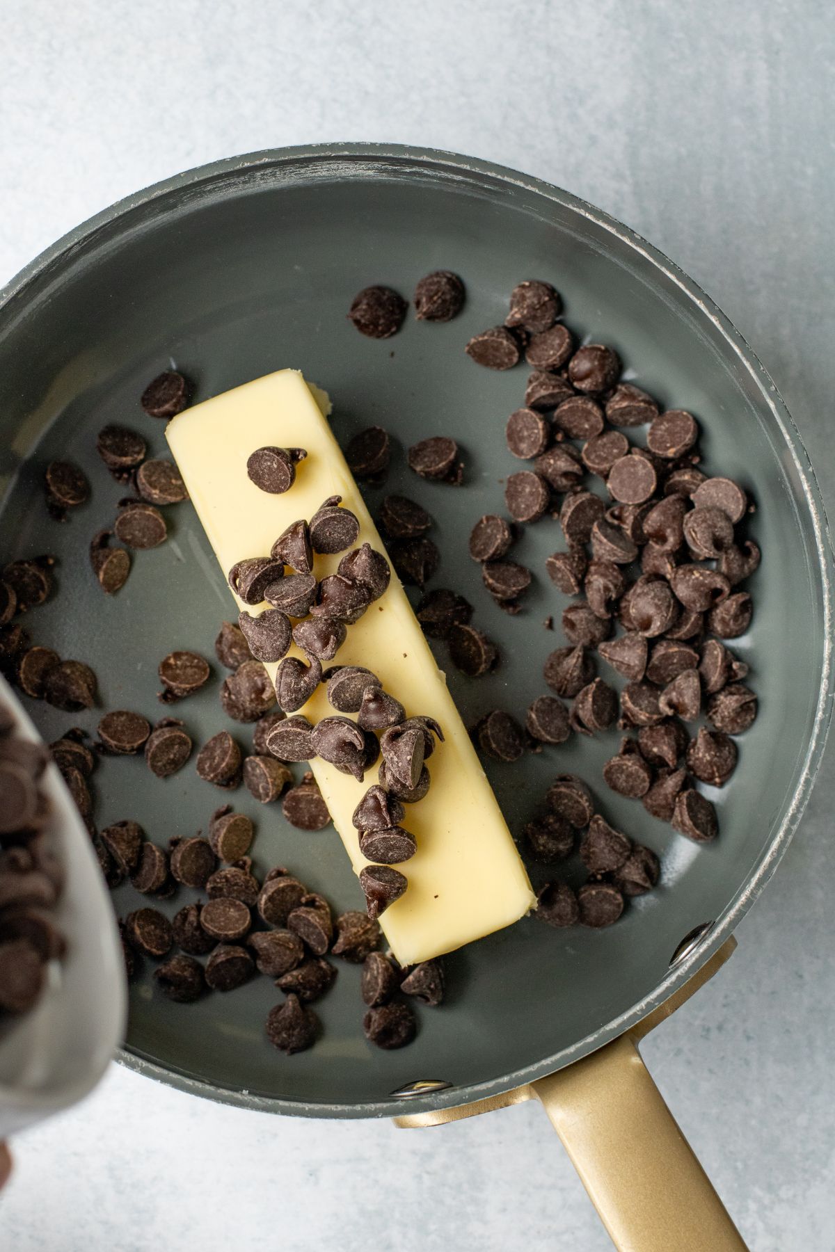 Butter and chocolate chips being melted together in a saucepan. 