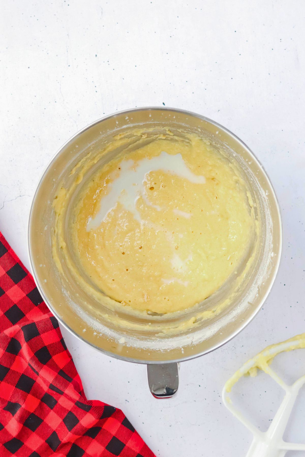 Cupcake batter mixed together in a silver mixing bowl. 