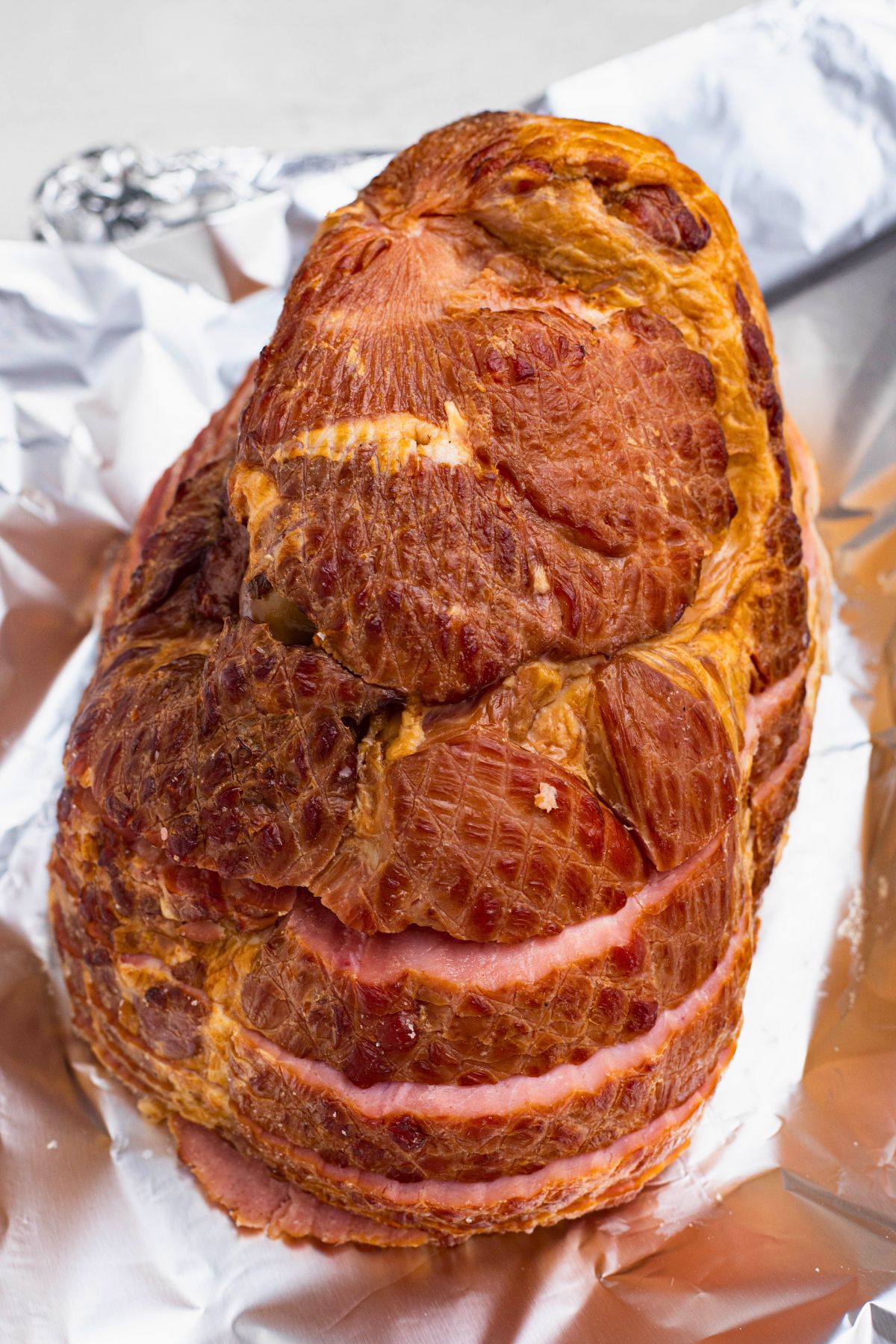 Spiral ham placed cut side down on foil in a pan. 