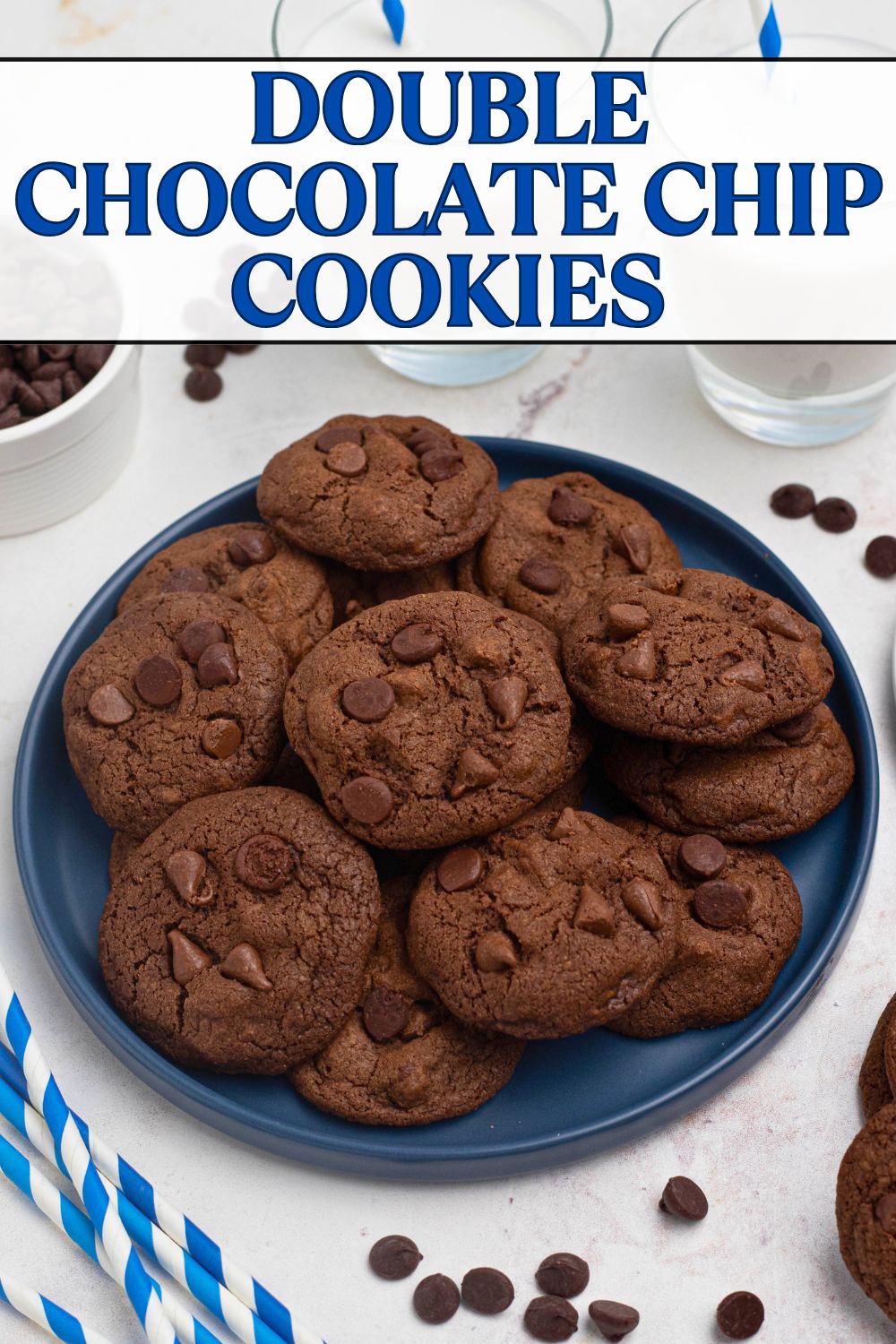 Double chocolate chip cookies stacked on a blue plate with chips and milk on the table.