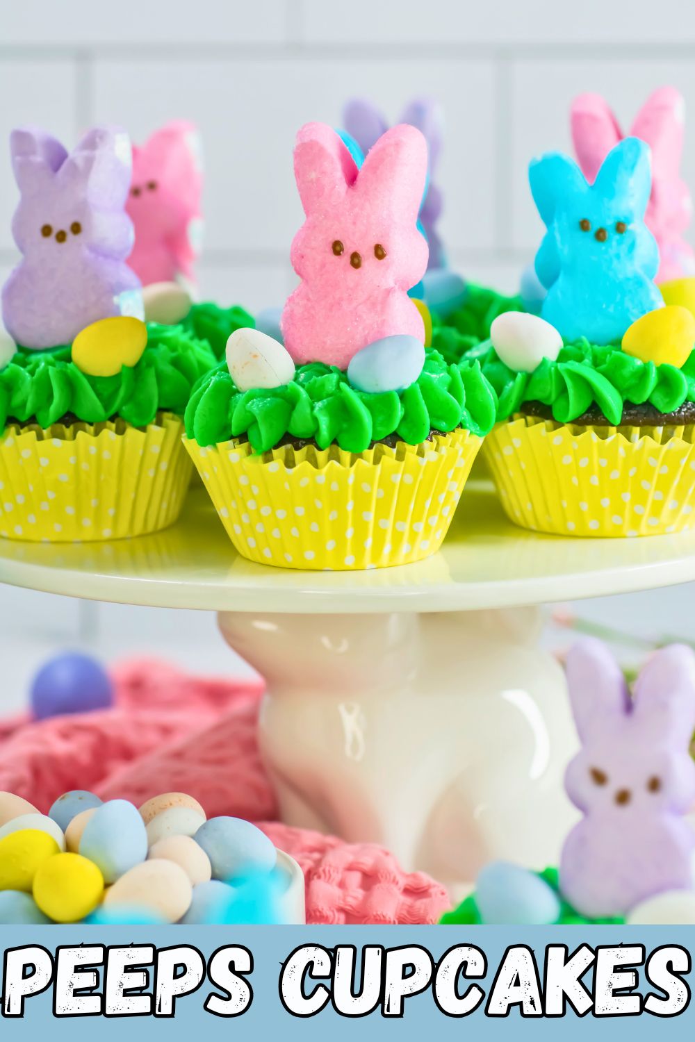 Peeps cupcakes with pastel bunnies on top of cake plate.
