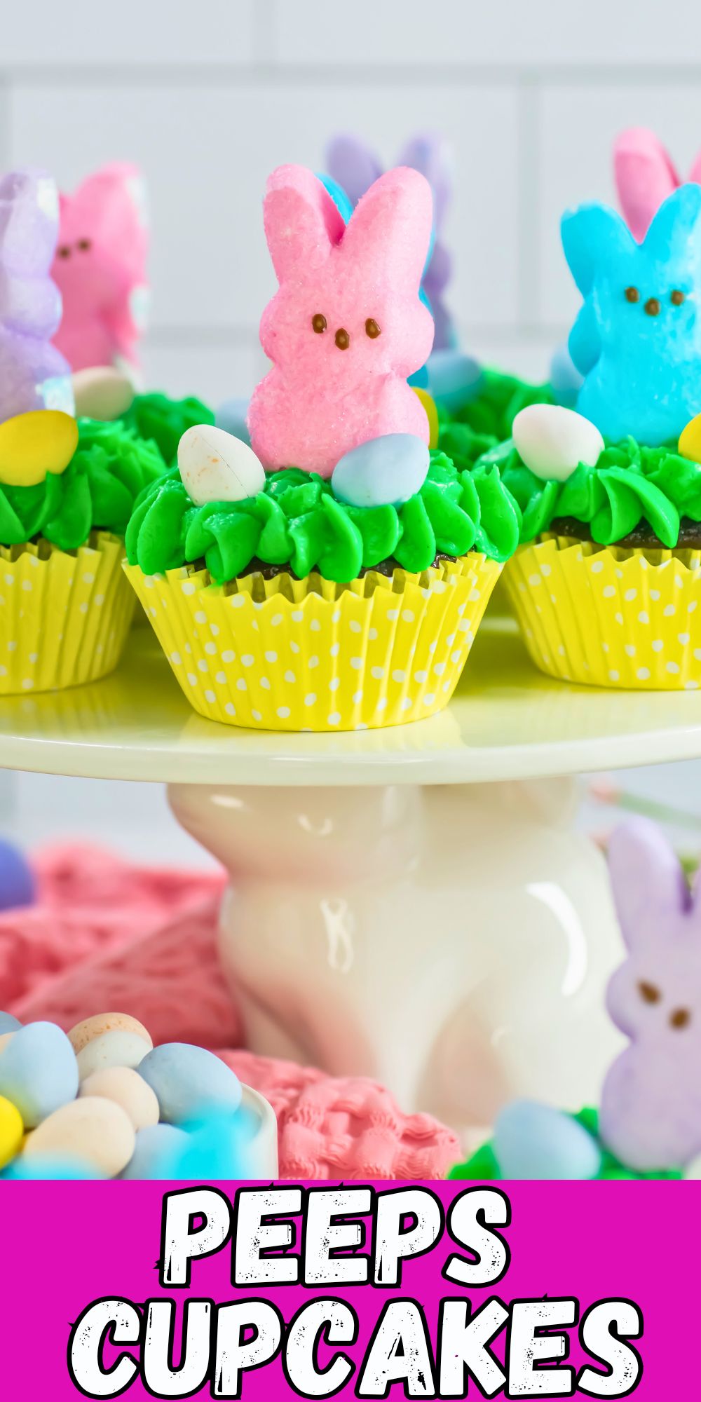 Peeps cupcakes with pastel bunnies on top of cake plate.