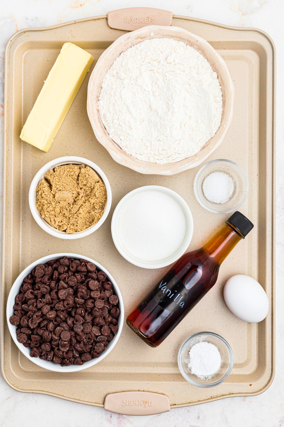 Ingredients needed to make cookies measured on a baking sheet. 