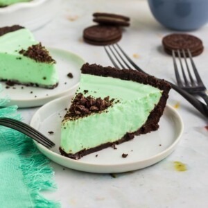 Grasshopper pie in a white pie dish with oreos on the table.